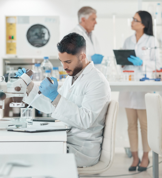 Isolated lab technician working solo under stress, while others converse nearby — symbolizing the need for connection.
